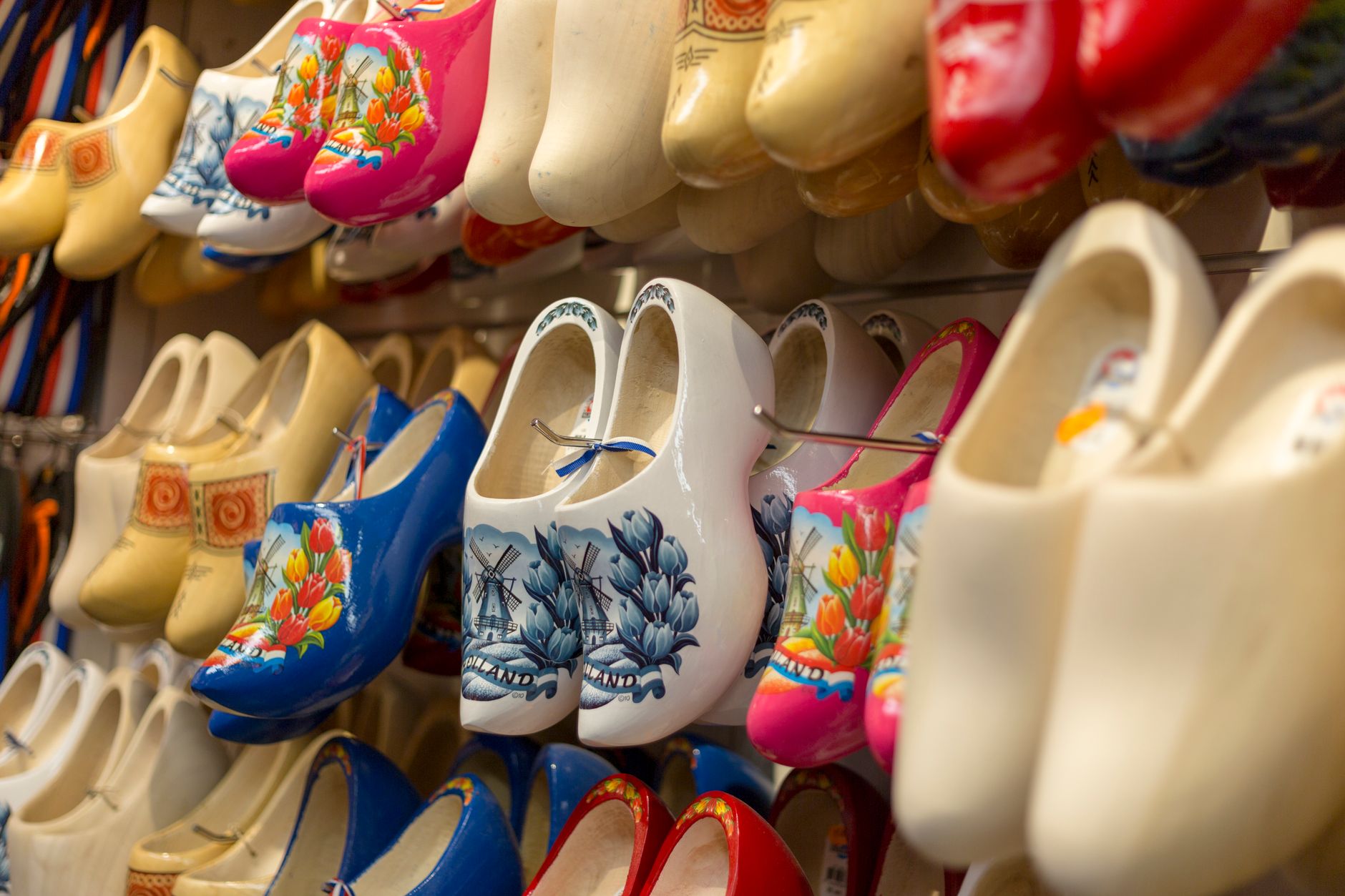 A vibrant collection of traditional Dutch wooden clogs displayed in a shop, showcasing colorful designs.